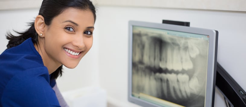 A woman smiling in from of a dental x-ray