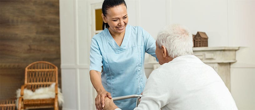 A PSW helping an elderly gentleman. Take the Personal Support Worker Program at Oxford.