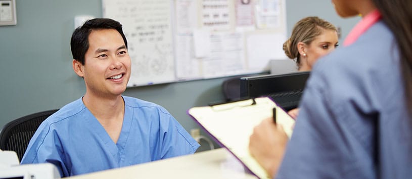 A medical office assistant at a desk. Take the Medical Office Assistant Program at Oxford!